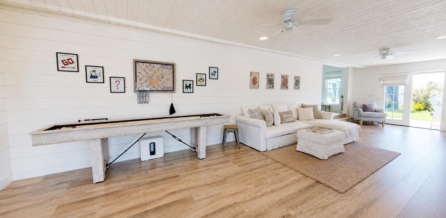 Funfilled game room featuring a Smart TV, shuffleboard, giant Connect Four, board games, and a pullout sofa.