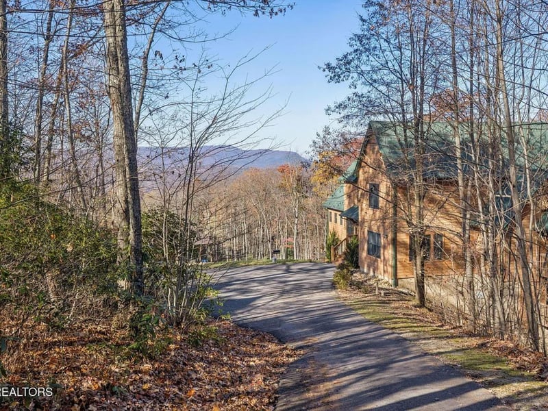 This charming mountain cabin sits nestled among trees along a peaceful private drive, with stunning distant mountain views and forested surroundings marking your arrival.