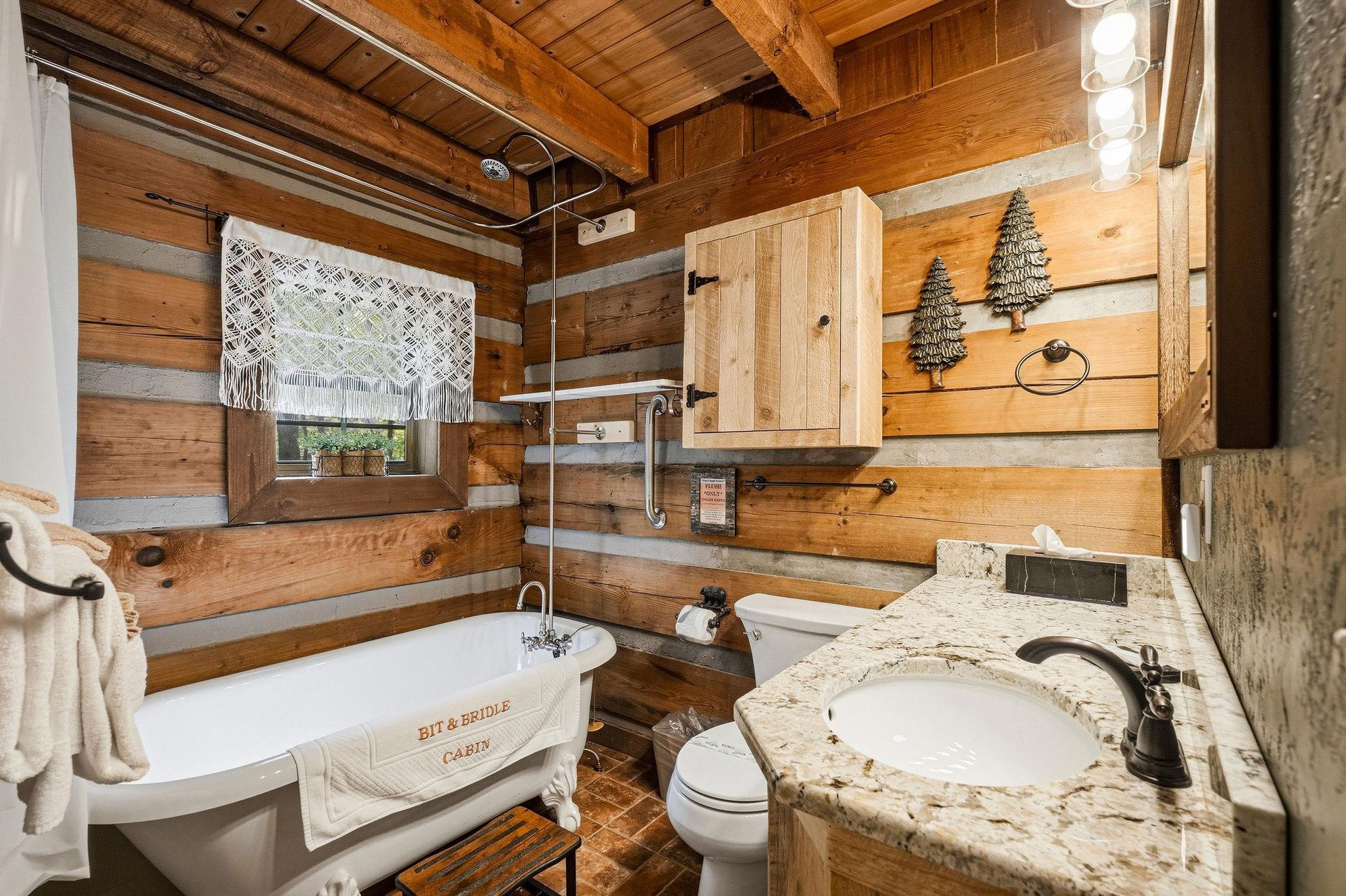 Warm wood surrounds you in this cozy cabin bathroom, where a soaking tub and granite vanity invite you to unwind after your mountain adventures.