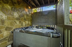 Unwind in your private hot tub, surrounded by natural stone walls and peaceful privacy screens for the ultimate relaxation experience.
