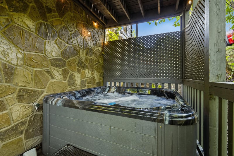 Unwind in your private hot tub, surrounded by natural stone walls and peaceful privacy screens for the ultimate relaxation experience.