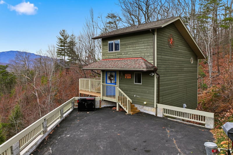 Mountain retreat with elevated deck and hot tub overlooking scenic forested hills and distant peaks.