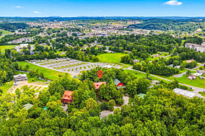 This aerial view captures the property nestled among lush greenery and rolling hills, offering a peaceful retreat surrounded by natural beauty.