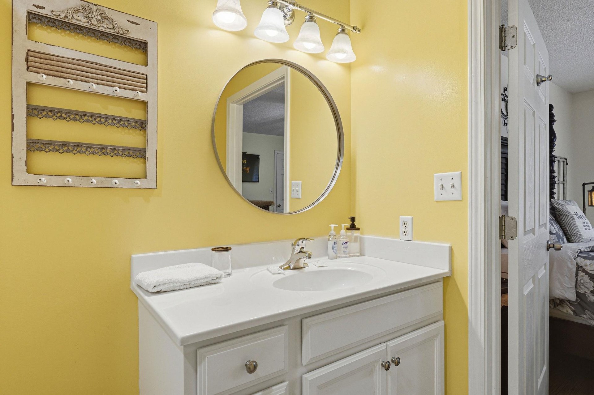 Freshen up at your private vanity with a bright mirror, soft towels, and cheerful yellow walls that bring warmth to your morning routine.