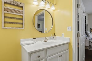 Freshen up at your private vanity with a bright mirror, soft towels, and cheerful yellow walls that bring warmth to your morning routine.