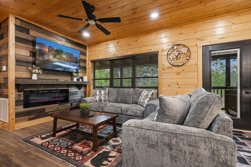 Sink into plush seating by your crackling fireplace, where rustic wood meets modern comfort in your mountain retreat.