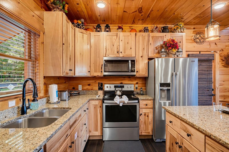 Step into your fully equipped kitchen, where warm knotty pine cabinetry meets modern stainless steel appliances. Granite countertops, a gas range, and all the essentials invite you to whip up memorabl