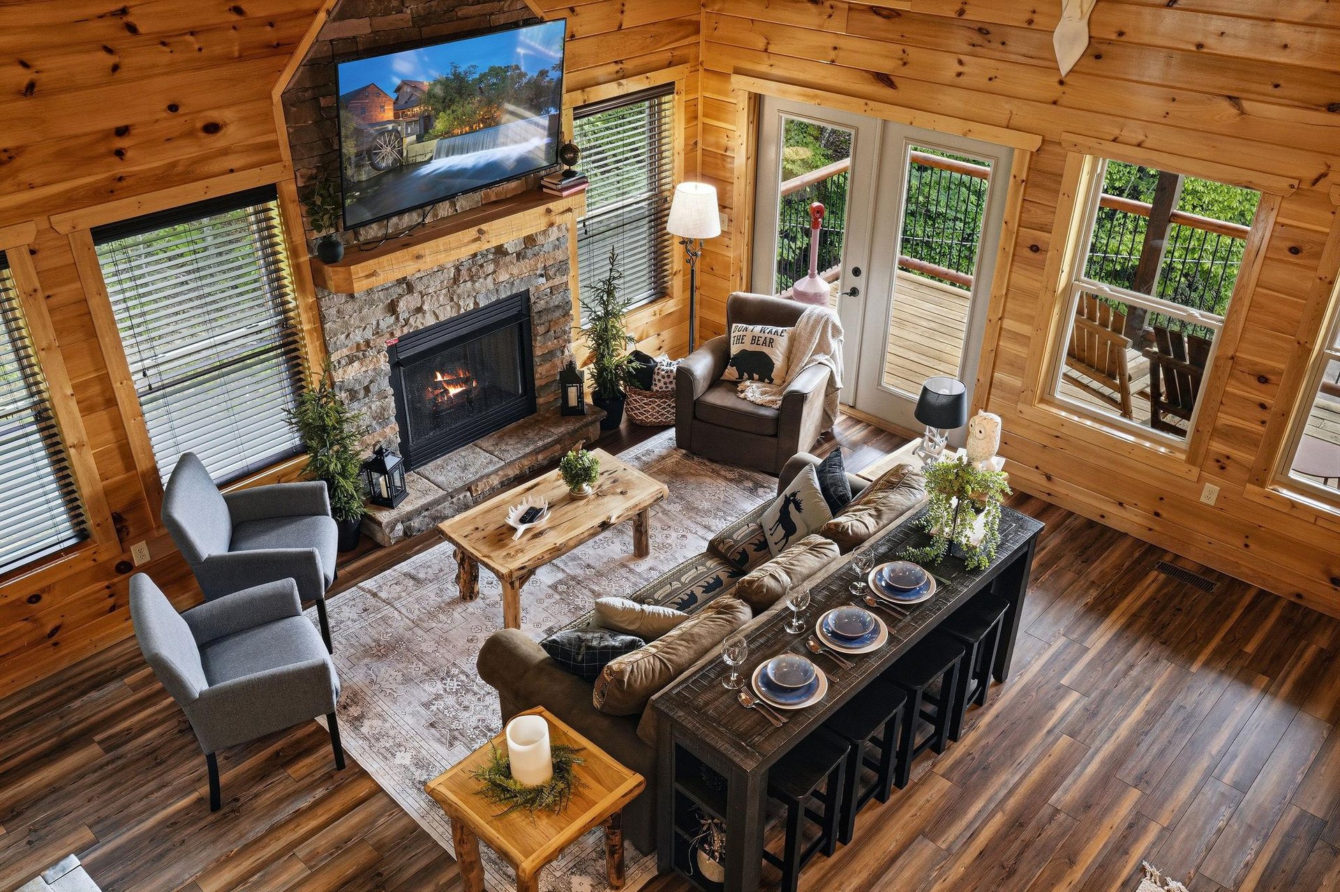 Settle into the inviting living room where rustic wood beams frame your mountain getaway. Cozy up by the fireplace, gather around the handcrafted coffee table, and step out to your private deck for fr