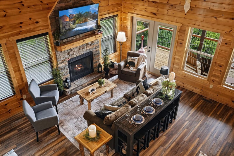 Settle into the inviting living room where rustic wood beams frame your mountain getaway. Cozy up by the fireplace, gather around the handcrafted coffee table, and step out to your private deck for fr