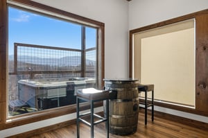 Sip your morning coffee at this charming barrel table while soaking in stunning mountain views through floortoceiling windows.