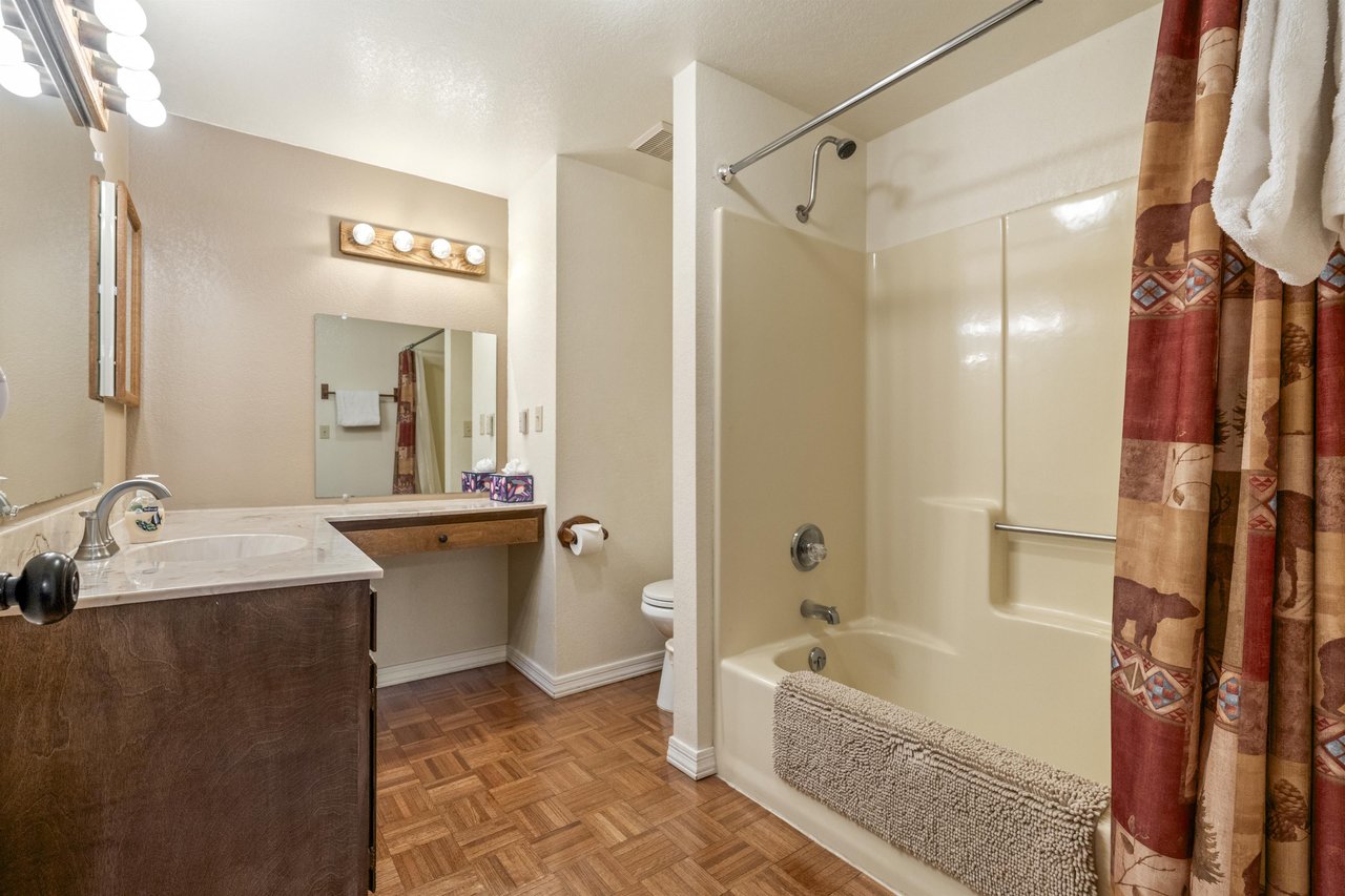 Ensuite primary bathroom with vanity space and a showertub combination.