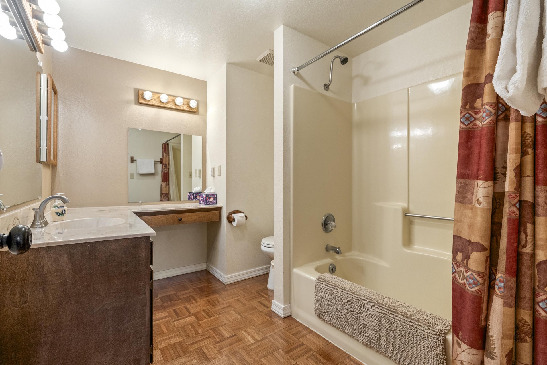 Ensuite primary bathroom with vanity space and a showertub combination.