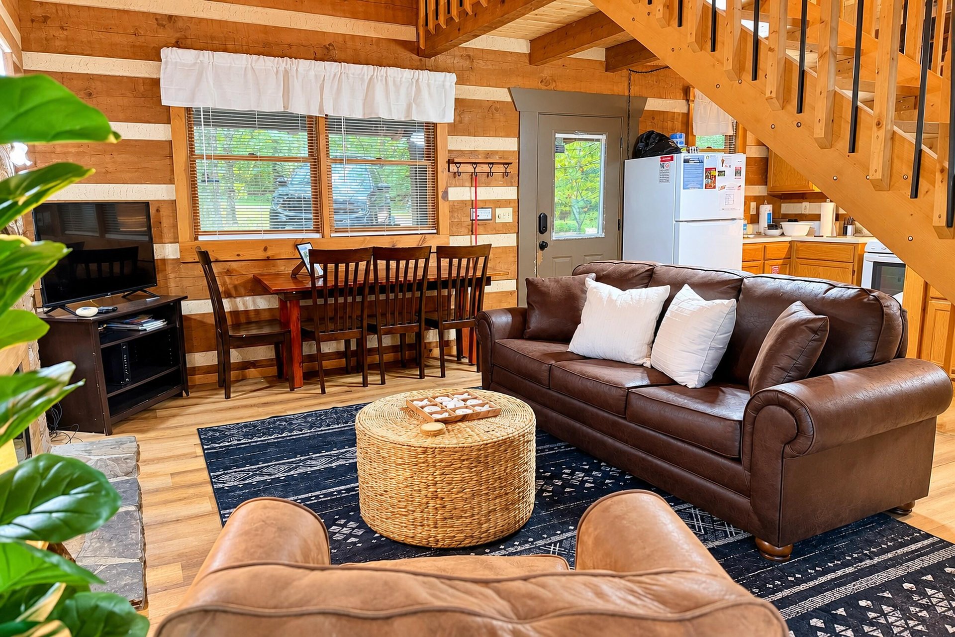 Unwind in your spacious, woodwrapped haven where a plush leather sofa invites you to relax. Sunlight filters through large windows, illuminating the warm tones and open layout—perfect for gathering, 