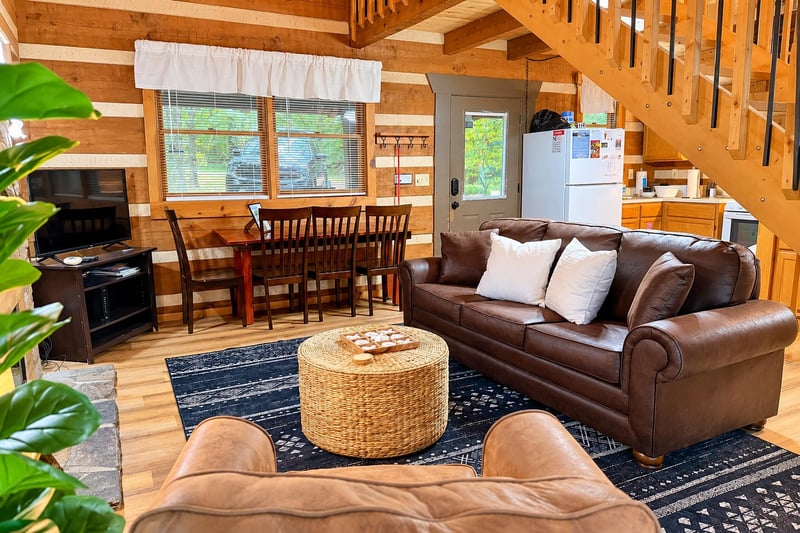 Unwind in your spacious, woodwrapped haven where a plush leather sofa invites you to relax. Sunlight filters through large windows, illuminating the warm tones and open layout—perfect for gathering, 