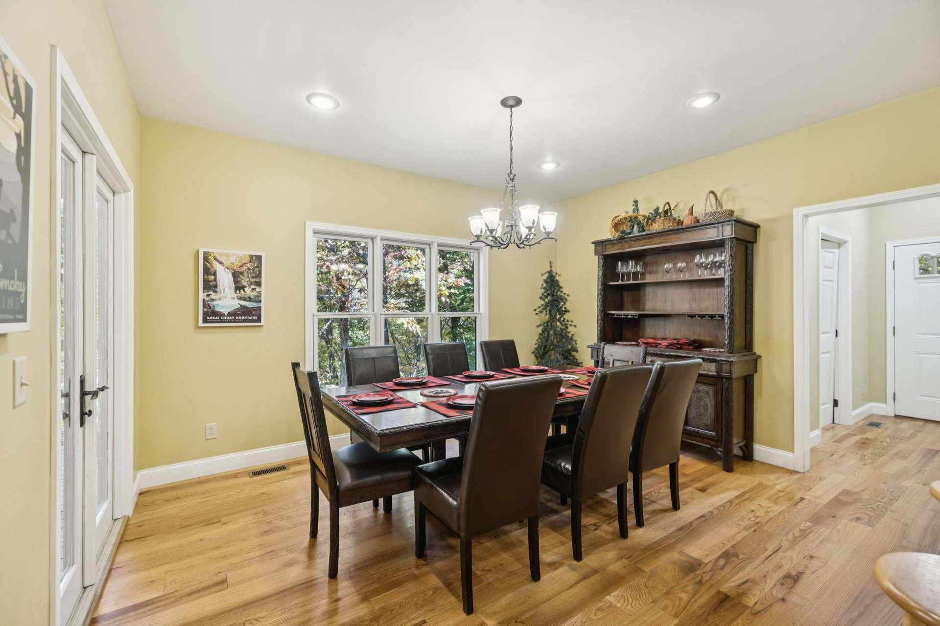 Gather around this inviting dining table, where meals become memories in a bright, cheerful space framed by garden views and warm wood tones.
