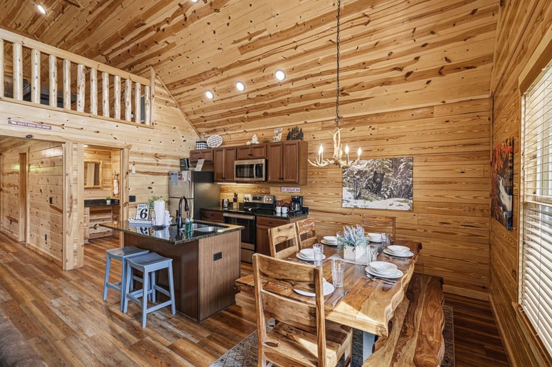 Your cozy mountain retreat features soaring wood ceilings, a fullyequipped kitchen with modern appliances, and a charming liveedge dining table where youll gather for meals, all wrapped in warm nat