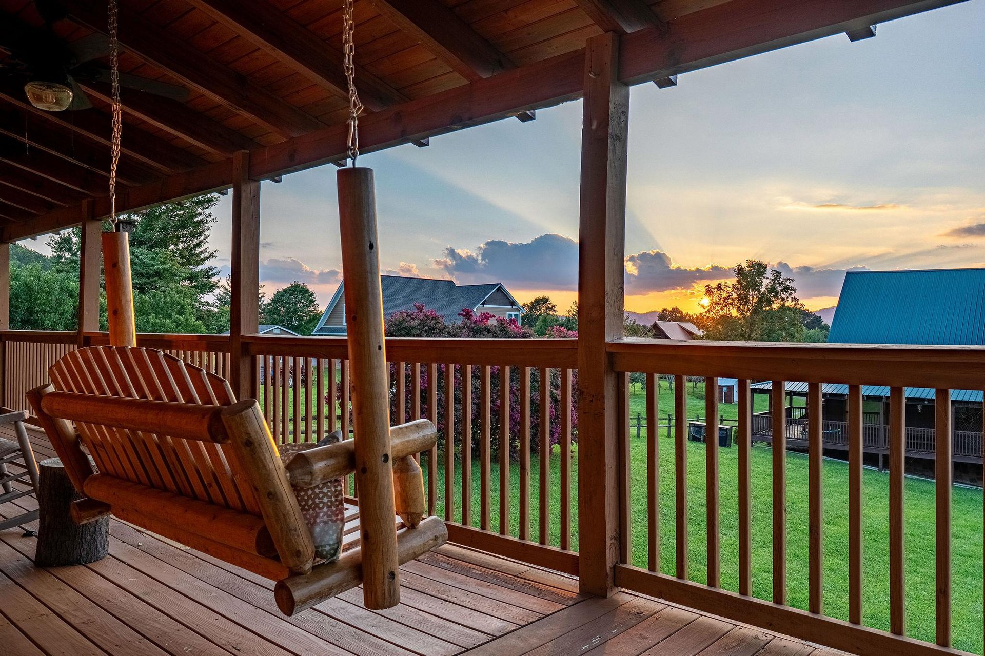 Swing gently on your private covered porch as the sun sets over the propertys peaceful grounds, painting the sky in soft gold and amber.