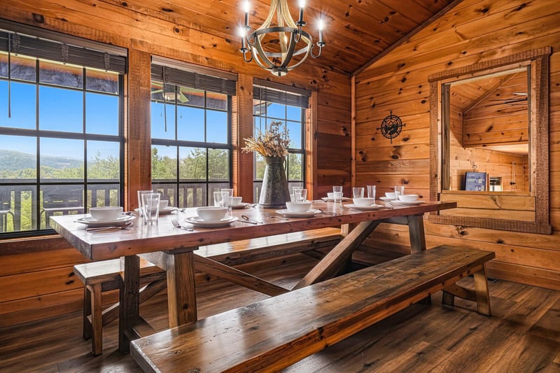 Gather around this handcrafted wooden table for family meals beneath the rustic chandelier, while the mountain view through the windows makes every bite more memorable.