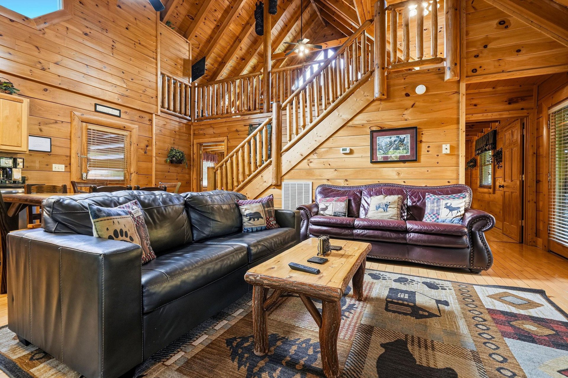 Sink into plush leather sofas surrounded by warm pine walls and rustic charm in your spacious mountain retreat living room.