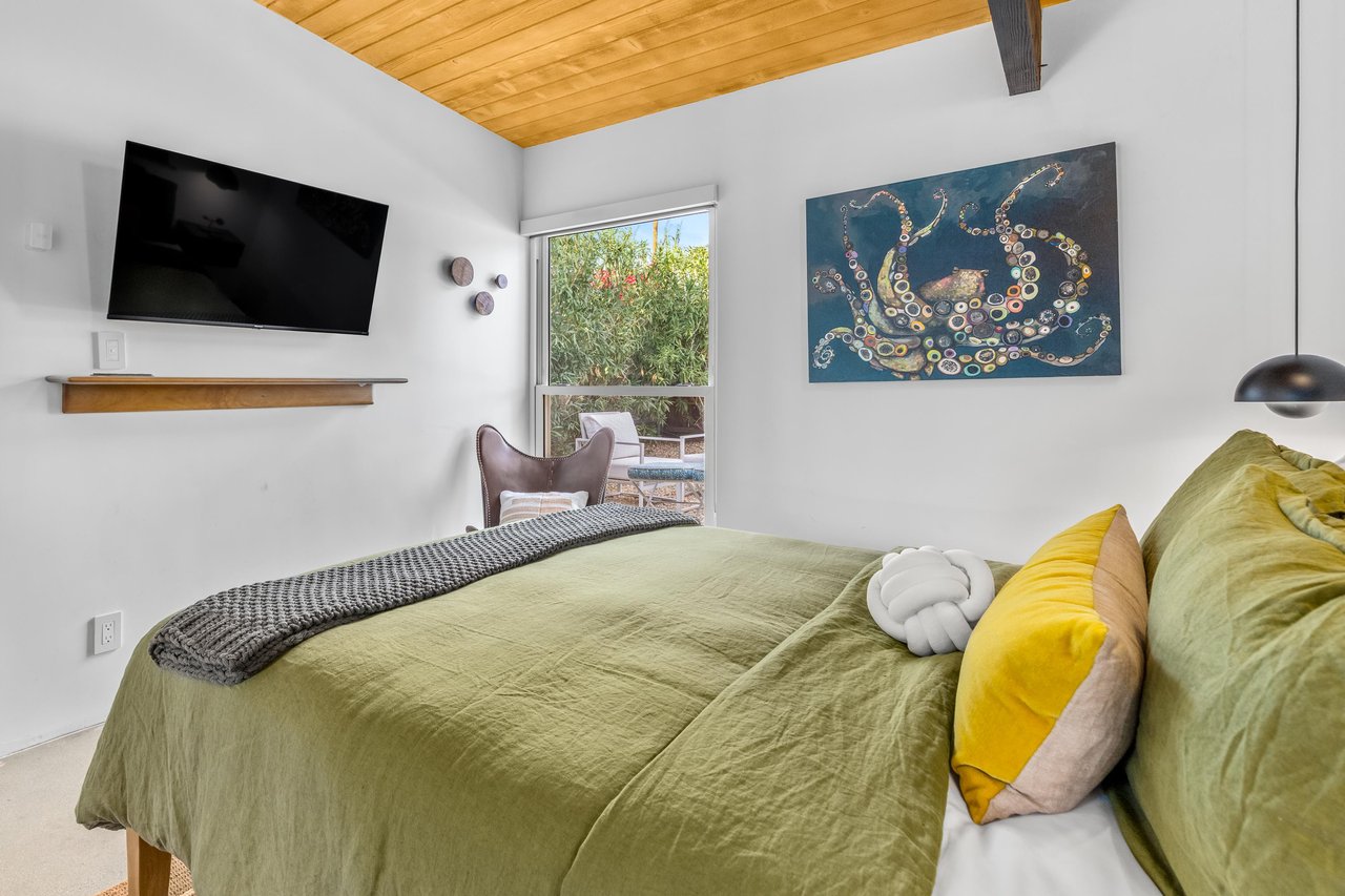 Sink into your dreamy retreat with olive green linens, warm wood ceilings, and modern touches creating the perfect escape.