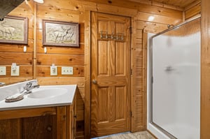 Step into your rustic cabinstyle bathroom, complete with warm pine walls, wildlife artwork, and a spacious walkin shower where you can unwind after a day of adventure.