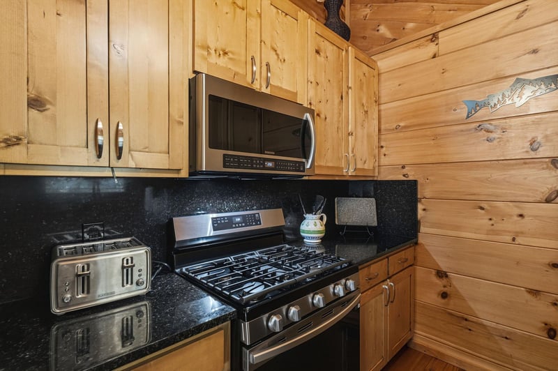 Enjoy homecooked meals in your fully equipped kitchen with stainless appliances, rich knotty pine cabinets, and elegant granite counters, all set within warm cabinstyle walls.