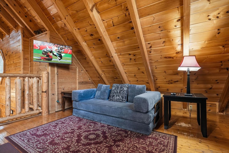 Cozy up in your private loft retreat with exposed timber beams, plush seating, and modern entertainment.