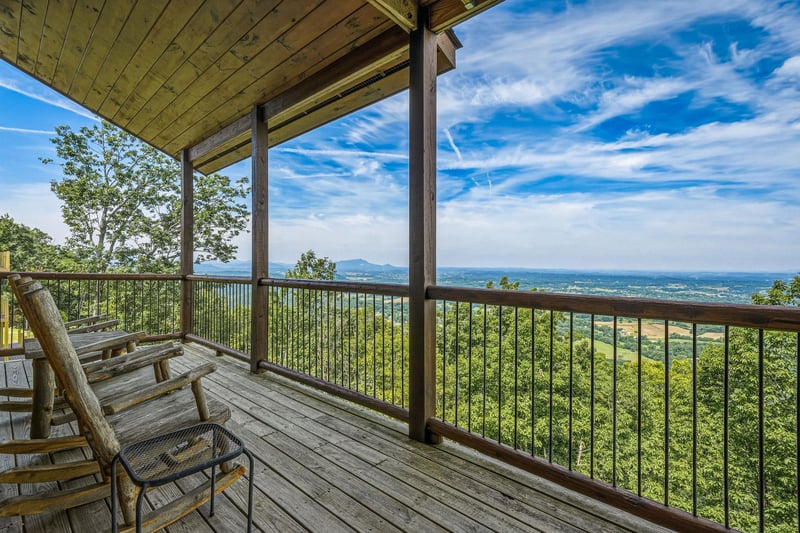 Sweeping mountain and valley views stretch endlessly from your private covered deck, where comfortable seating invites peaceful mornings and tranquil evenings surrounded by natural beauty.