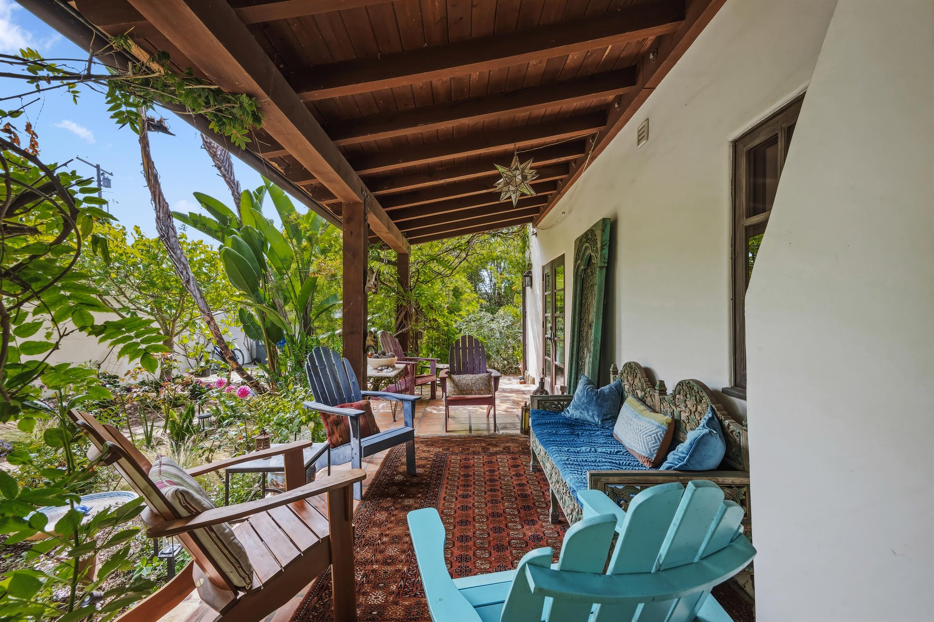 Stunning patio with mosaic tiles, outdoor seating, and an outdoor shower.