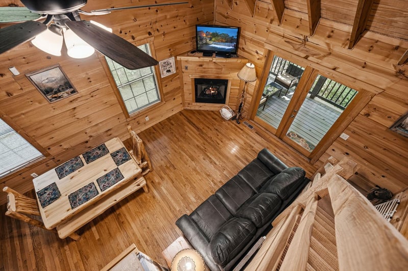 Take in the vaulted ceilings and cozy mountain charm from this lofted perspective. Wood beams frame your comfortable living space, complete with plush seating, a warm fireplace, and large windows welc