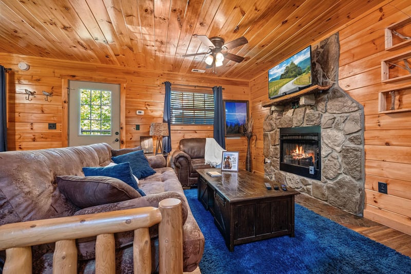 Living room with blue rug and stone fireplace
