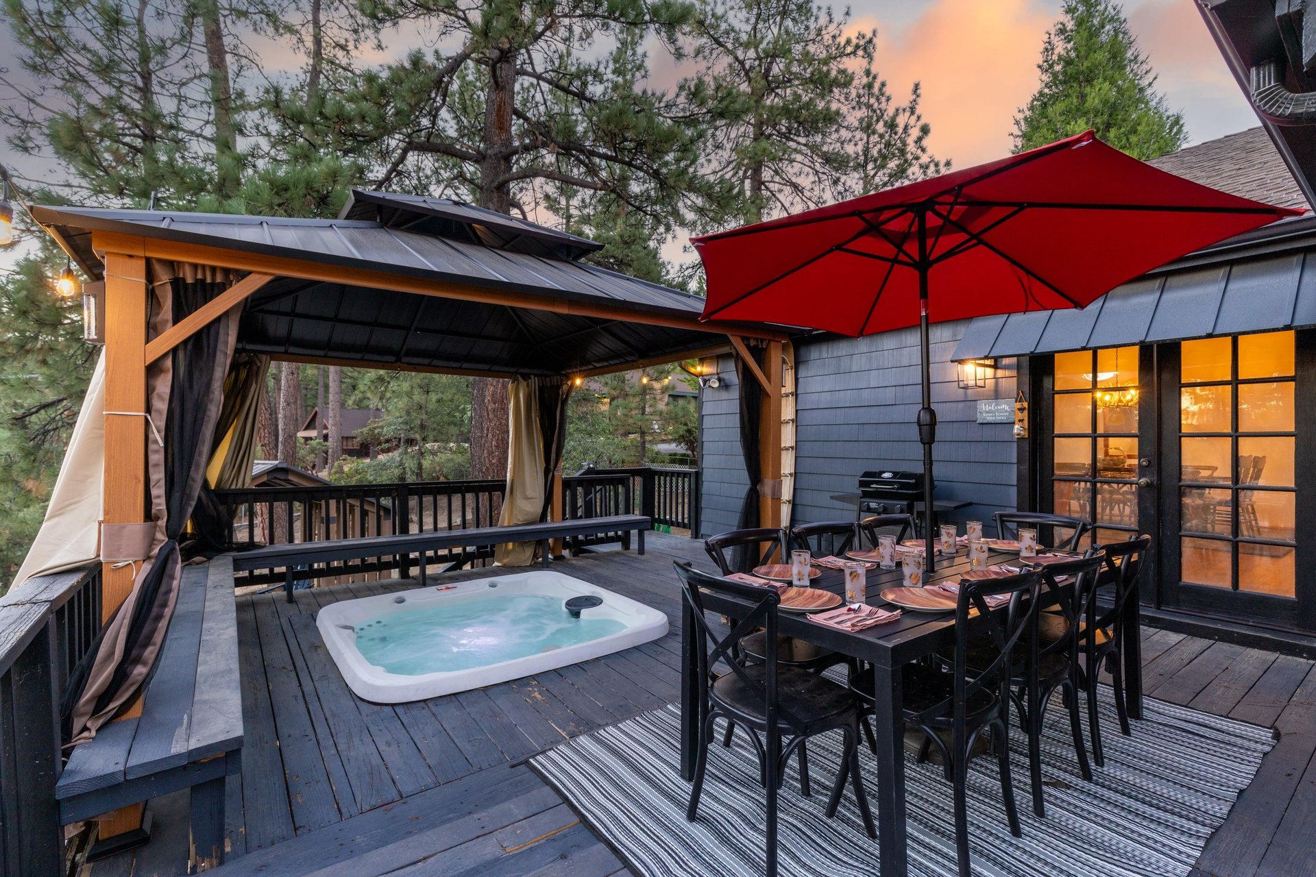 Beautiful wraparound deck with outdoor dining, covered private hot tub, and BBQ.