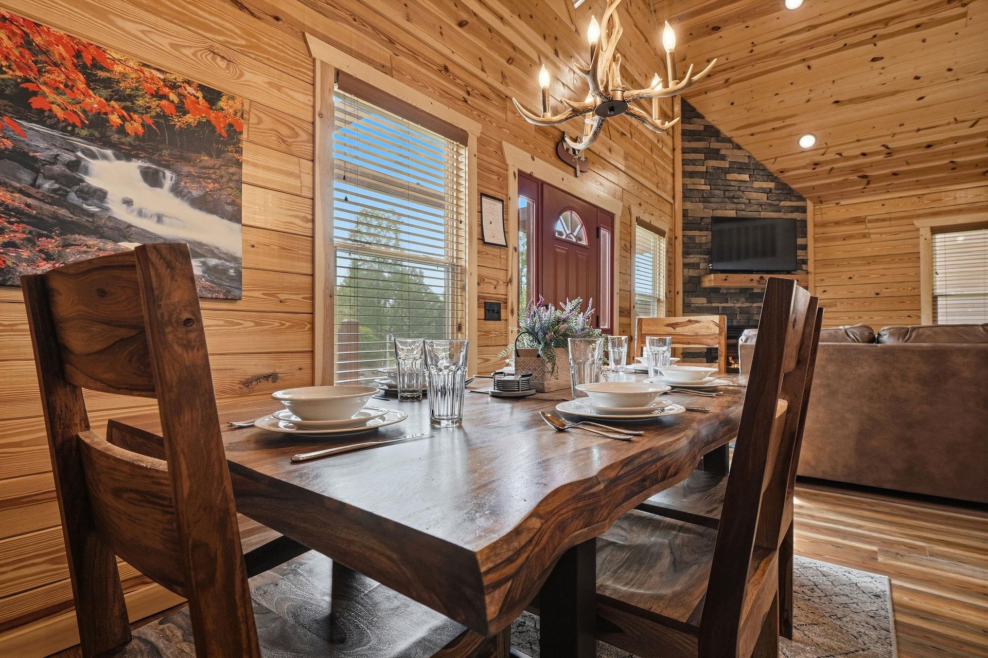 Step inside your cozy cabin where rustic charm meets modern comfort. Natural pine walls and warm lighting welcome you to gather around a beautifully set table, perfect for creating memorable moments t