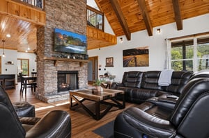 Gather around the stone fireplace and sink into plush leather seating beneath soaring woodbeamed ceilings. Natural light floods your open, inviting space—your perfect mountain escape.