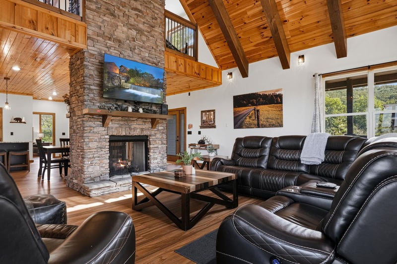 Gather around the stone fireplace and sink into plush leather seating beneath soaring woodbeamed ceilings. Natural light floods your open, inviting space—your perfect mountain escape.