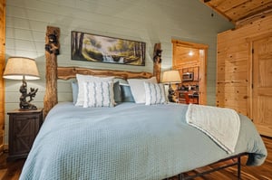 Unwind in your cozy bedroom featuring a handcrafted log bed frame and warm wooden details. Fresh linens and rustic charm create your peaceful mountain retreat.