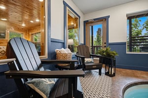 Sink into plush seating on your private patio, where tall glass doors frame leafy views and invite fresh air to flow through. A perfect spot for morning coffee or evening relaxation.