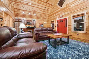 Sink into plush leather seating in your rustic cabin retreat, where warm wood walls and modern comfort blend seamlessly together.