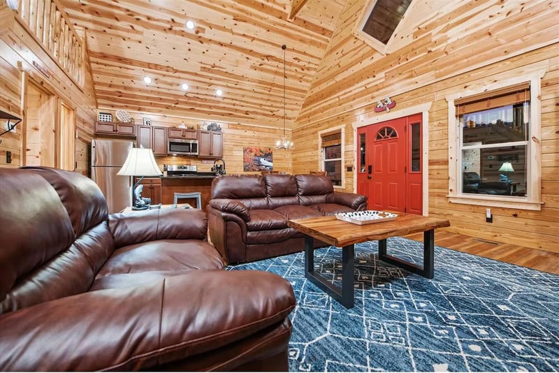 Sink into plush leather seating in your rustic cabin retreat, where warm wood walls and modern comfort blend seamlessly together.