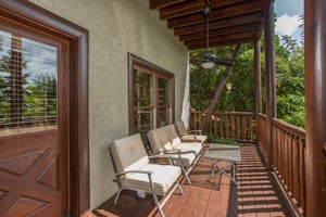 Deck with chairs and a table at Graceland, a 4bedroom cabin rental located in Pigeon Forge