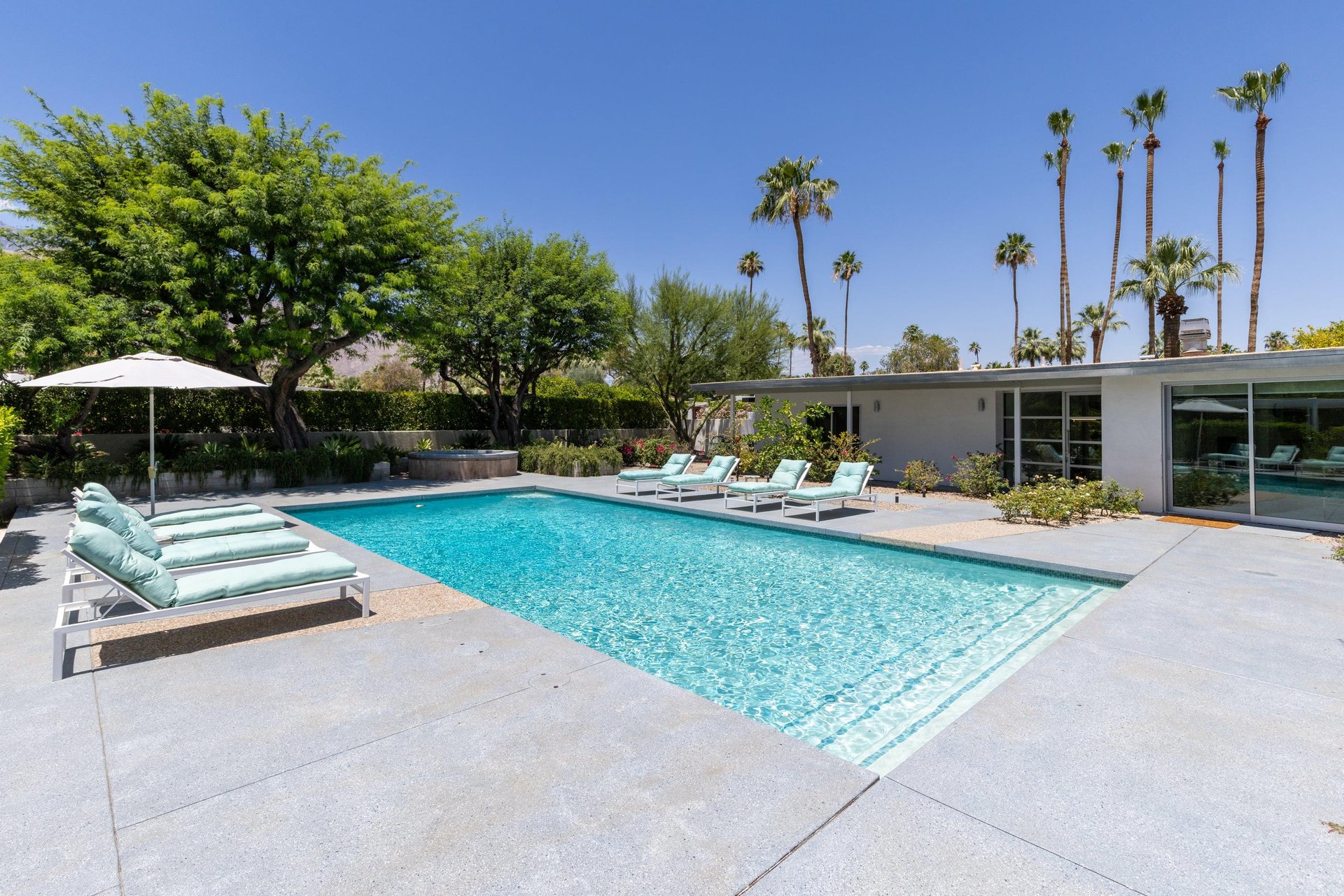 Private poolspa with sun loungers and umbrellas.