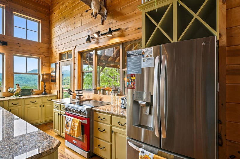 Step into a bright, welcoming kitchen where rustic charm meets modern convenience. Sunlight streams through tall windows, framing stunning mountain views that accompany your morning coffee and every m
