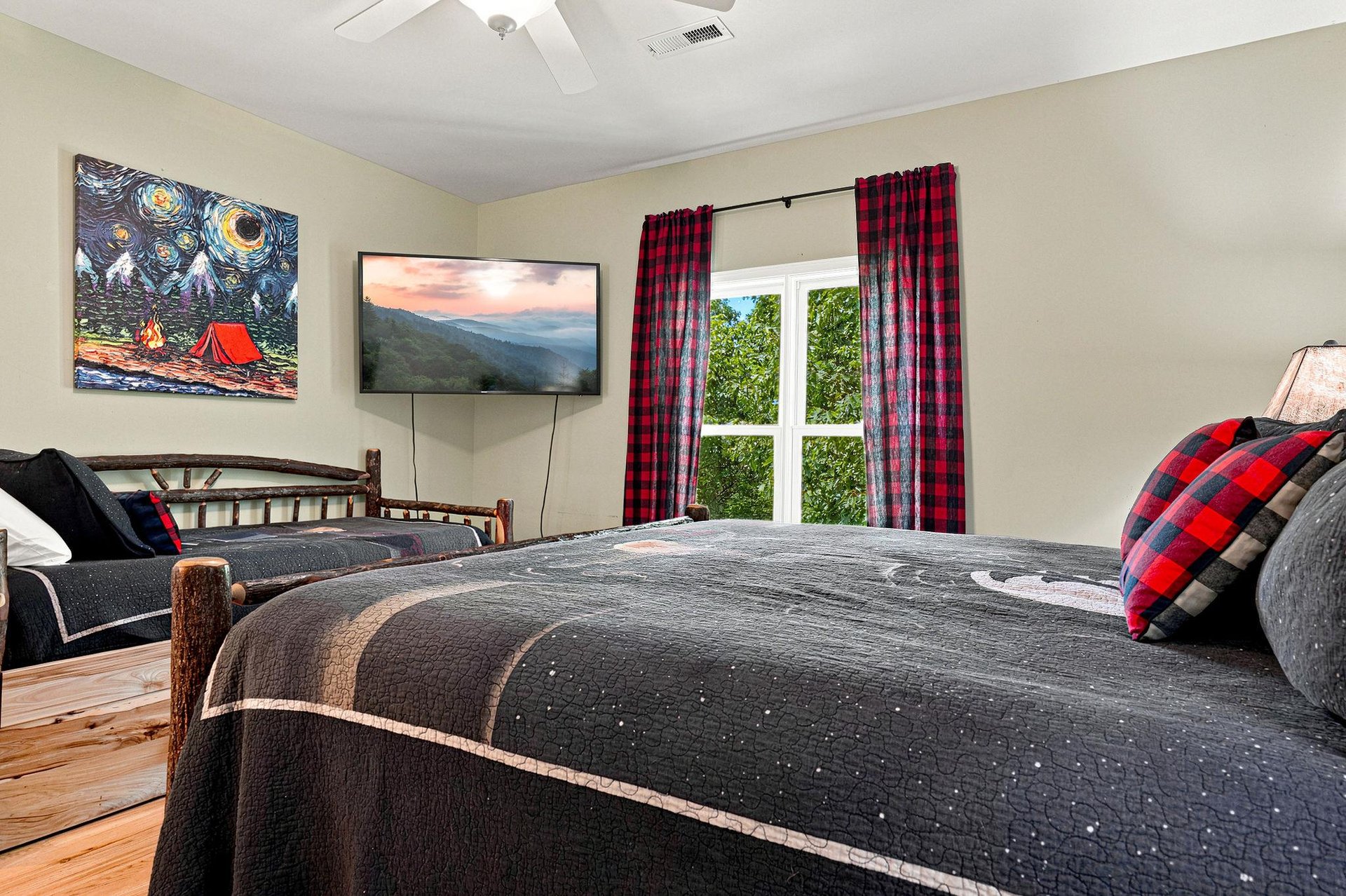 Unwind in your cozy bedroom with a plush bed, ceiling fan overhead, and a TV for your favorite shows. Natural light and nature views complete the peaceful retreat.