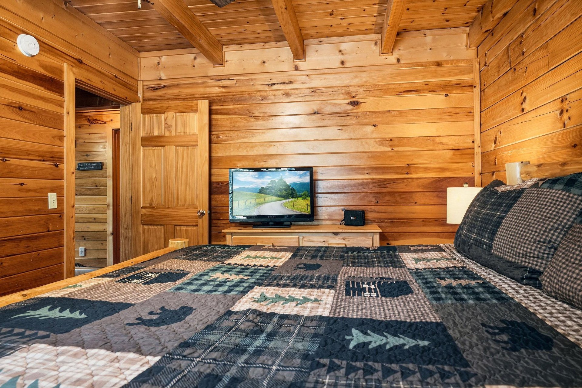 Sink into your cozy bed surrounded by warm wood walls and watch your favorite shows on the flatscreen TV in this rustic retreat.