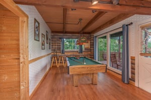 Green felted pool table in a game room at Bushwood Lodge, a 3bedroom cabin rental located in Gatlinburg