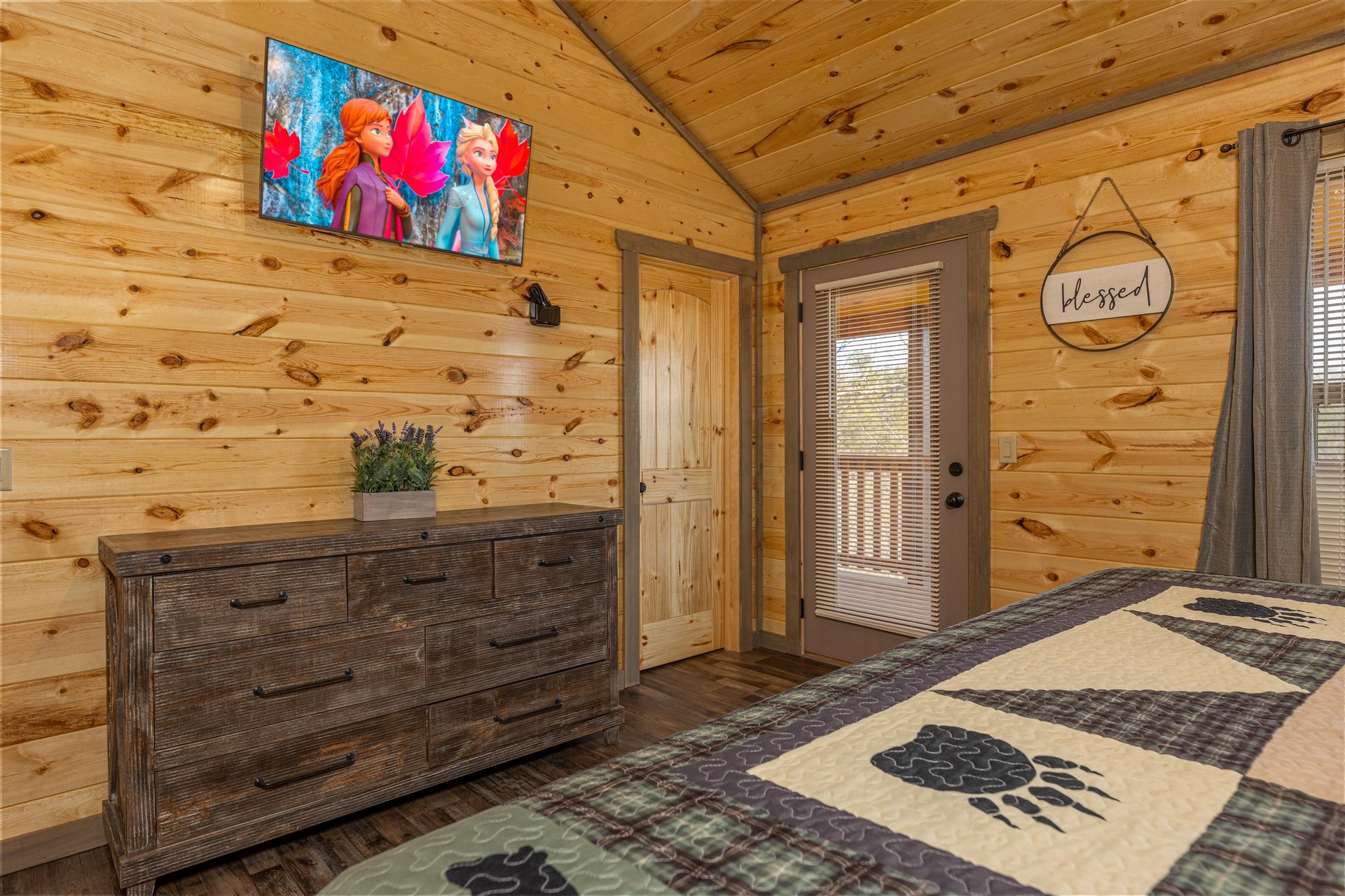 Dresser and TV in a bedroom with deck access at Everlys Splash, a 4 bedroom cabin rental located in Pigeon Forge