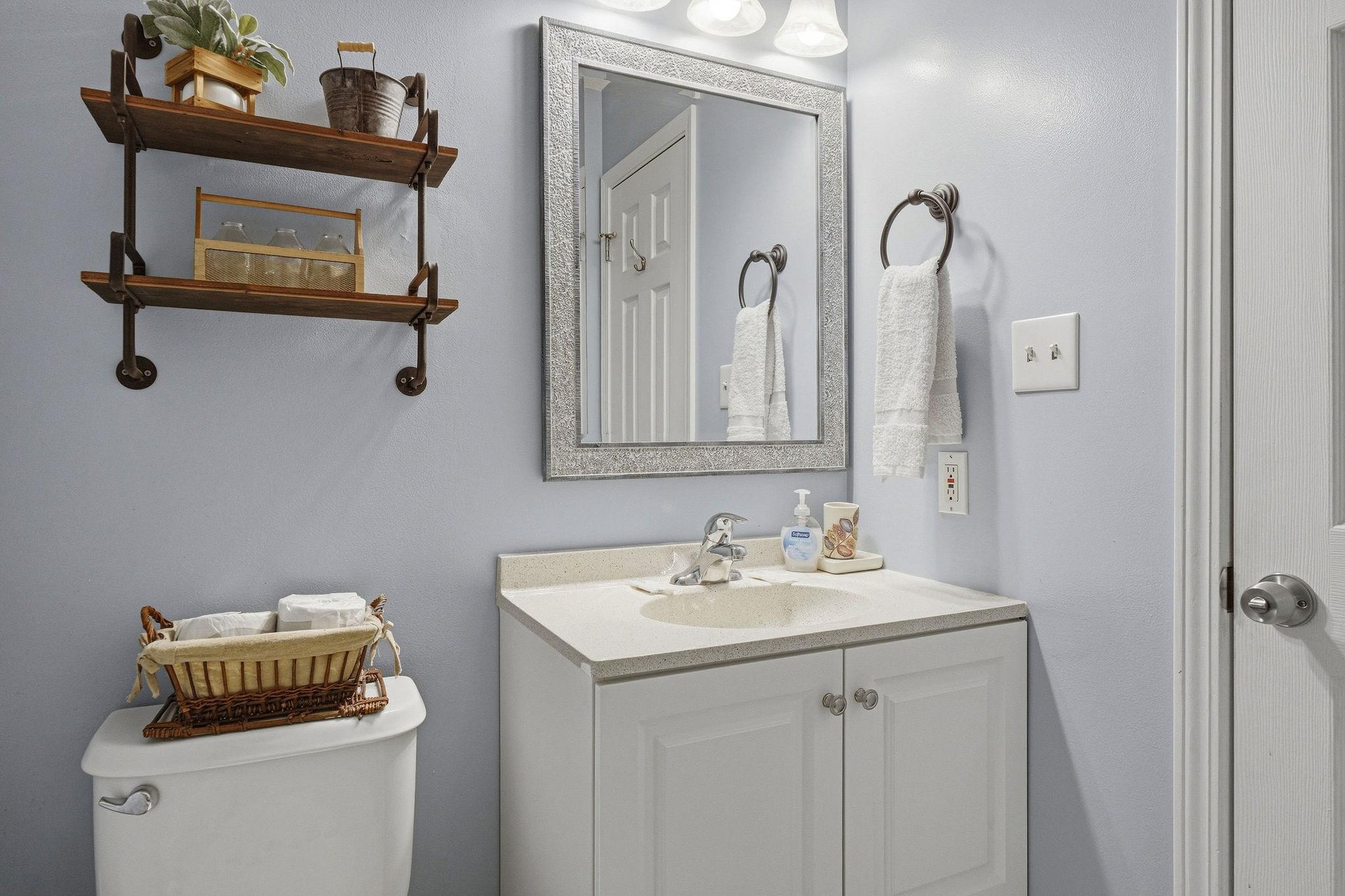 Step into your private bathroom, where soft blue walls and rustic wood accents create a calm, welcoming retreat. Fresh towels await, and every detail is designed for your comfort.