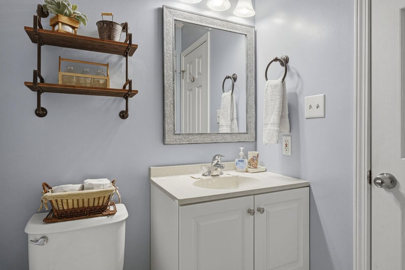 Step into your private bathroom, where soft blue walls and rustic wood accents create a calm, welcoming retreat. Fresh towels await, and every detail is designed for your comfort.