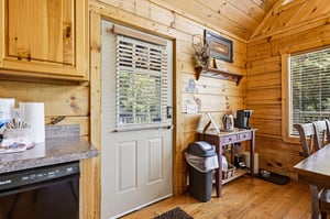 Step into your cozy cabin kitchen where warm pine walls and thoughtful touches create a welcoming retreat. Everything you need awaits in this charming space with natural light streaming through the wi