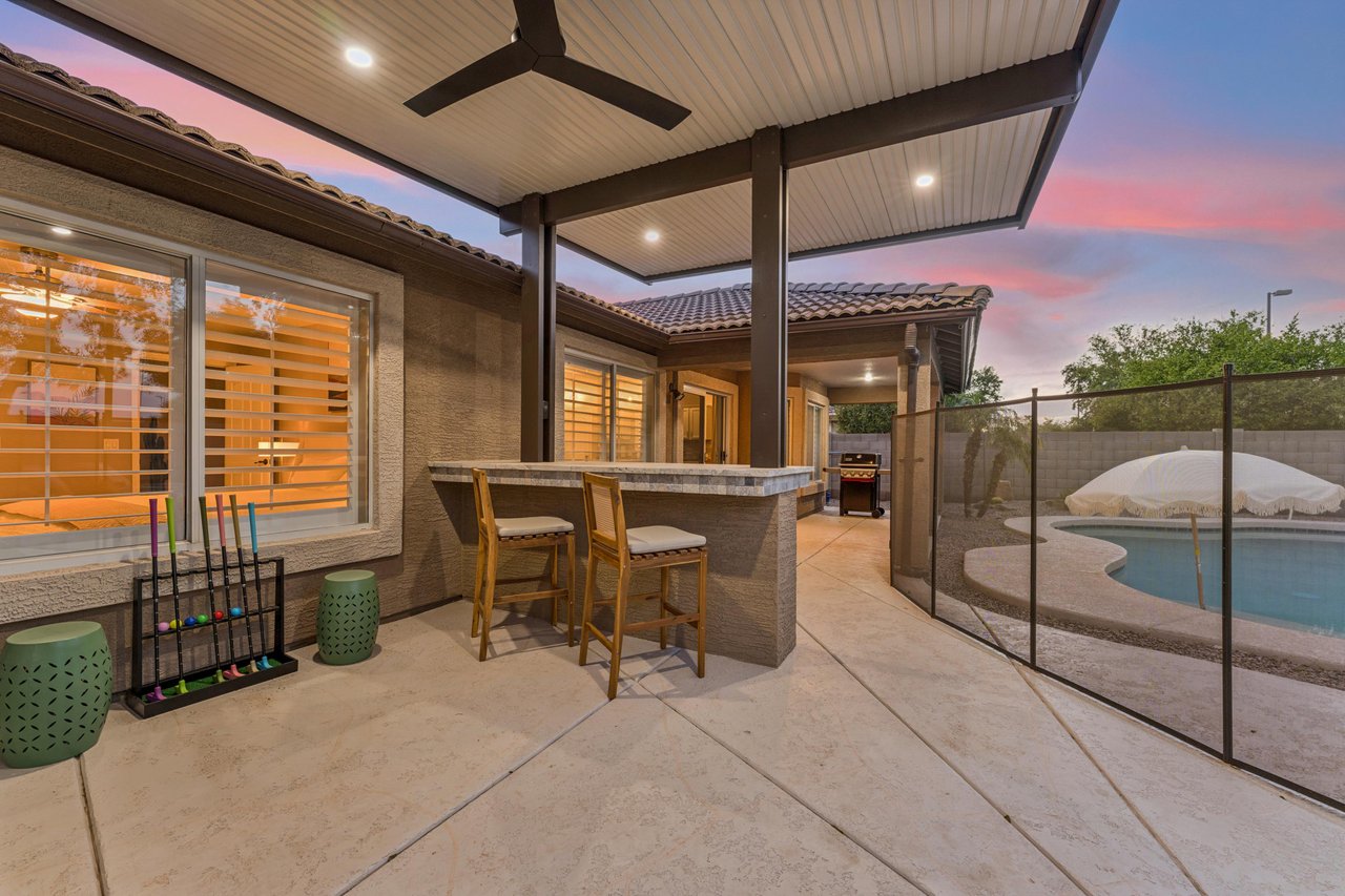 Patio perfecting for entertaining with outdoor seating, flatscreen TV, fan, and BBQ.